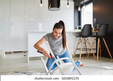 Young Woman At Home Refurbishing A Chair As Upcycling As A Handyman