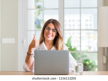 Young Woman At Home Using Laptop Happy With Big Smile Doing Ok Sign, Thumb Up With Fingers, Excellent Sign