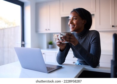 Young Woman At Home Working On Laptop On Counter In Kitchen - Powered by Shutterstock