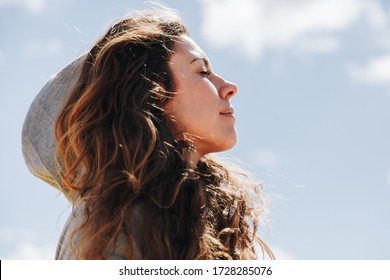 Young woman with hood resting while standing breathes deeply - Powered by Shutterstock