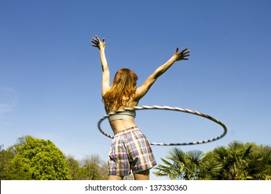 Young Woman With Hoola Hoop In Park