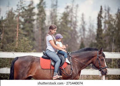 The Young Woman Horseback Riding At Summer Evening