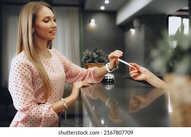 Young Woman Hotel Guest Receiving Key Card From Receptionist