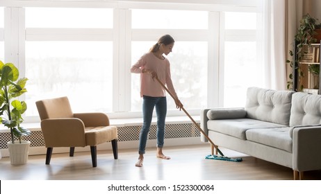 Young Woman Housewife Clean Wash Hardwood Floor In Modern Living Room Interior, Tidy Girl Cleaner Maid Holding Mop At Home, Housekeeping And Household, Domestic Housework Cleaning Service Concept