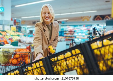 A Young Woman, Housewife, Go To The Supermarket And Buy Groceries For His Family. Woman Cook Breakfast, Lunch, Dinner And Everything She Wrote On Her Shopping List. She Chooses, Fruits, Vegetables