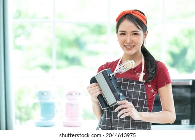 Young Woman Housewife Holding Electric Food Mixer For Make A Bread In The Kitchen 
