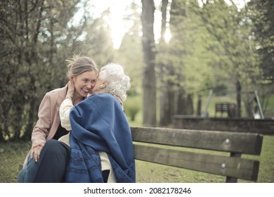 junge Frau, die mit ihrer Großmutter im Park umarmt