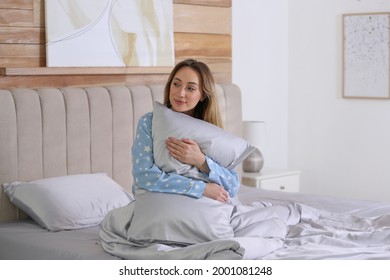 Young Woman Hugging Pillow On Comfortable Bed With Silky Linens