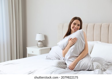 Young Woman Hugging Pillow On Comfortable Bed With Silky Linens