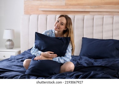 Young Woman Hugging Pillow On Comfortable Bed With Silky Linens