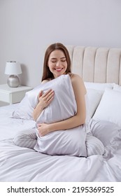 Young Woman Hugging Pillow On Comfortable Bed With Silky Linens