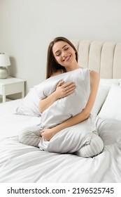 Young Woman Hugging Pillow On Comfortable Bed With Silky Linens