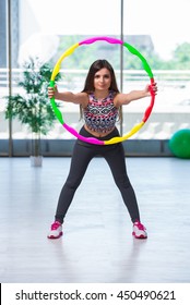 Young Woman With Hula Loop In Gym In Health Concept