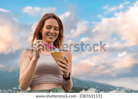 Young woman with ice cream walking in the street