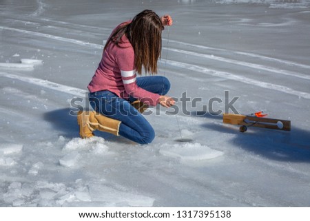 Young woman ice fishing