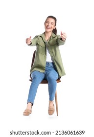 Young Woman With Imaginary Steering Wheel Sitting In Chair On White Background