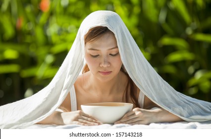 A Young Woman Inhale Steam Of Boiled Salt Water Cover With White Cloth.