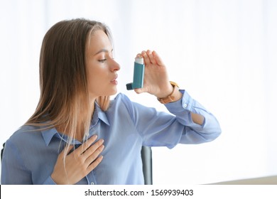 Young Woman With Inhaler Having Asthma Attack In Office