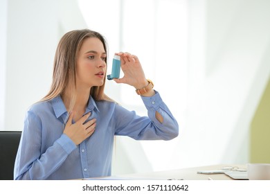 Young Woman With Inhaler Having Asthma Attack In Office