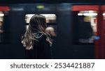 Young woman inside underground station while train passing. Lifestyle real image.