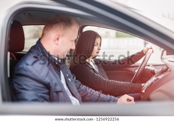 Young woman with\
instructor sitting in car