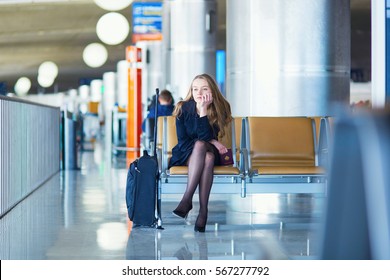 Young Woman In International Airport, Waiting For Her Flight, Looking Upset Or Worried. Missed, Canceled Or Delayed Flight Concept