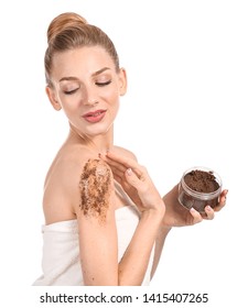 Young woman with jar of body scrub on white background
