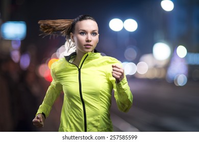 Young woman jogging at night in the city - Powered by Shutterstock