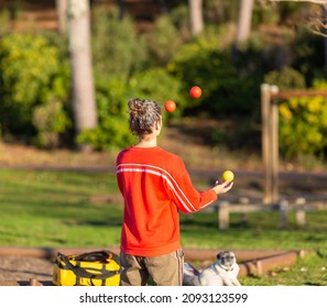 Young Woman Juggling Balls On The Promenade