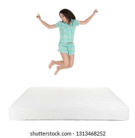 Young woman jumping on mattress against white background