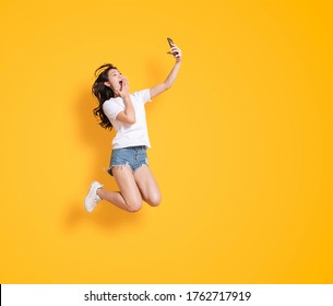  Young Woman Jumping While Watching The Mobile Phone 