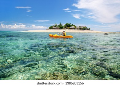 Young woman kayaking near South Sea Island, Mamanuca islands group, Fiji. This group consists of about 20 islands.