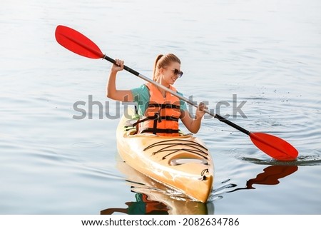 Young woman kayaking in river