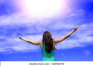 Young woman keeps the arms open into the sky