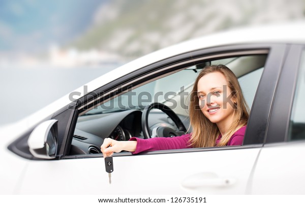 Young woman\
with keys of new , hire or rental\
car