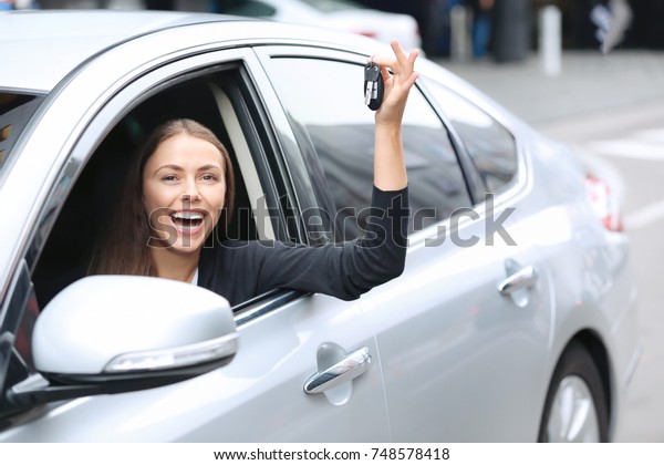 Young woman with\
keys on driver\'s seat of\
car
