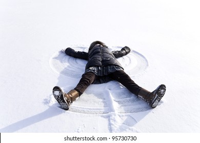 Young Woman Kidding On Snow In Winter Day