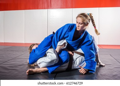 A Young Woman In A Kimono Makes A Painful Reception. Judo, Jujitsu. Tatami, Gym