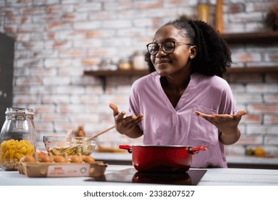 Young woman in kitchen. Beautiful African woman cooking pasta.	 - Powered by Shutterstock