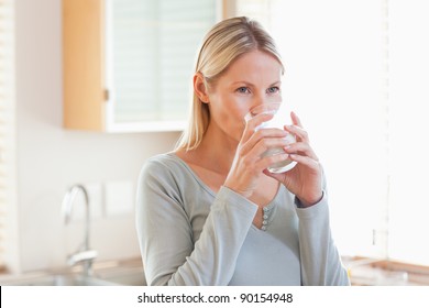 Young Woman In The Kitchen Drinking Water