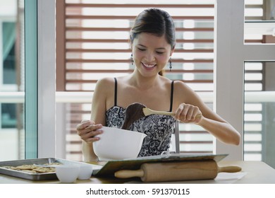 Young Woman In Kitchen Holding Mixing Bowl