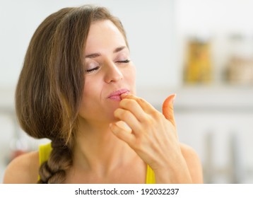 young-woman-kitchen-licking-fingers-260nw-192032237.jpg