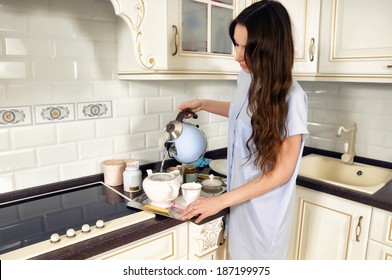 Young Woman In The Kitchen Making Tea              