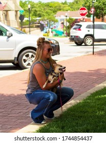 A Young Woman Kneeling Down With Her Dog