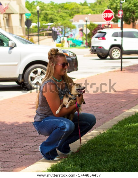 A Young Woman\
Kneeling Down With Her Dog