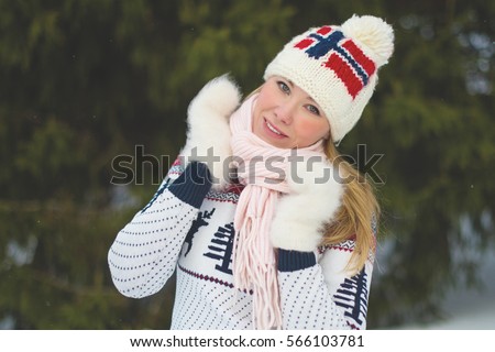 Young woman in knitted hat with Norwegian flag and scandinavian sweater. Winter landscape