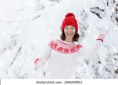 Young Woman In Knitted Sweater Playing Snow Ball Fight In Winter. Girl In Family Snow Balls Game. Female In Knit Handmade Hat And Mittens With Christmas Snowflake Design Having Fun In Snowy Park.