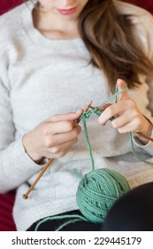 Young Woman Knitting At Home