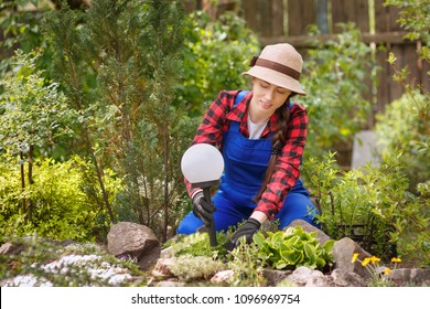 Young Woman Landscape Designer Installations Decorative Lamp On Flower Bed