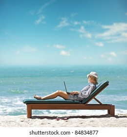 Young Woman With Laptop At The Beach